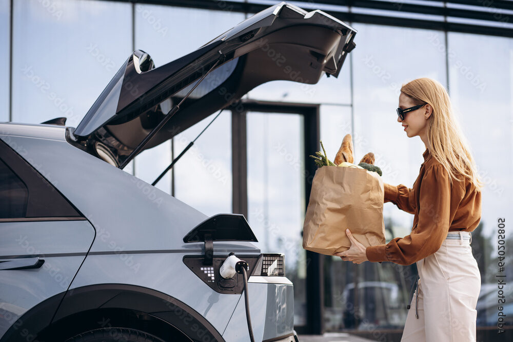 Woman loading groceries into EV