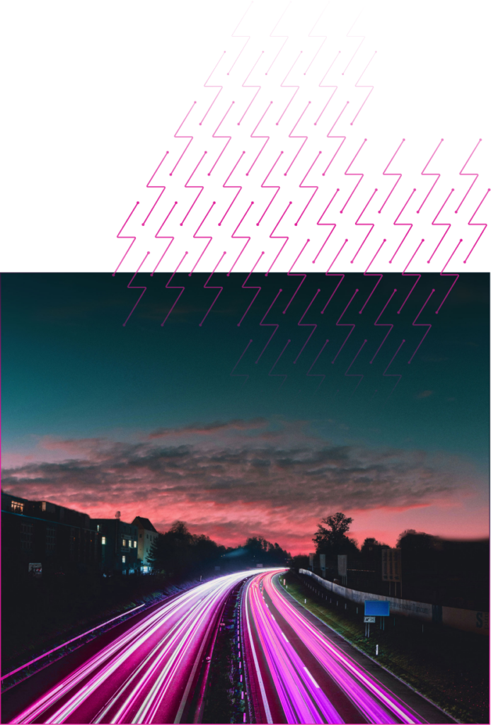 A long exposure photo of pink headlights on a road at twilight