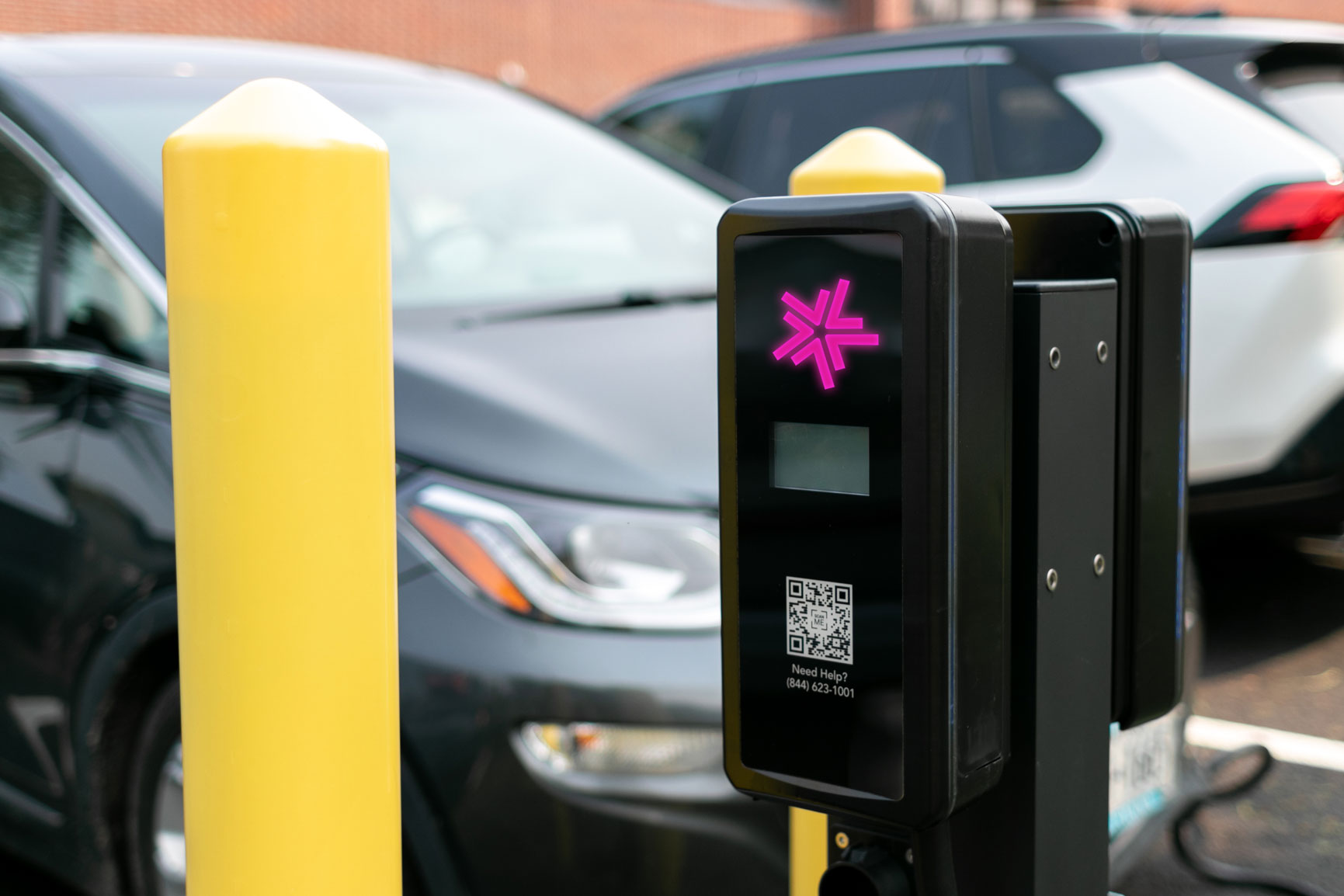 A close-up of a Lynkwell charing station in a parking lot