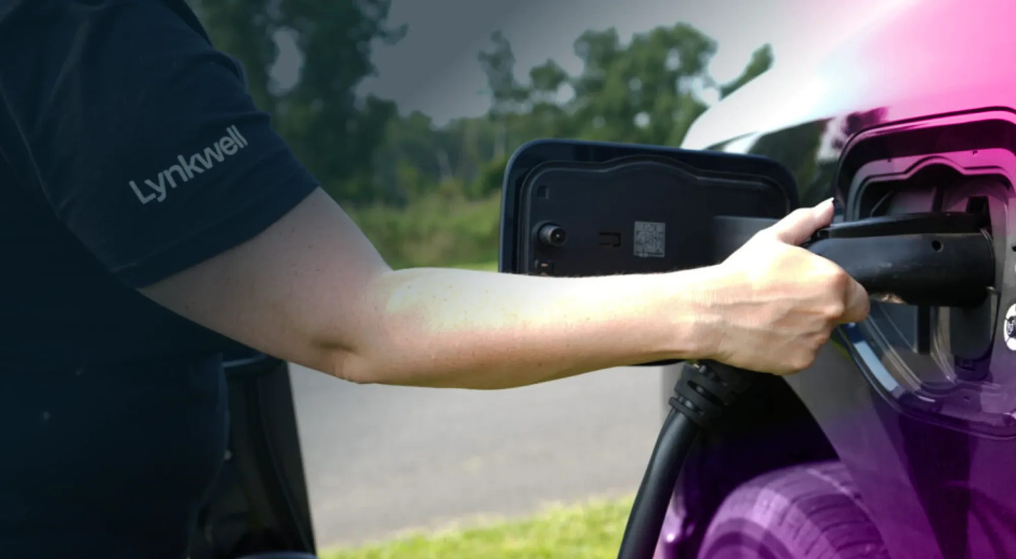 A man plugging a Lynkwell EV charger into his car