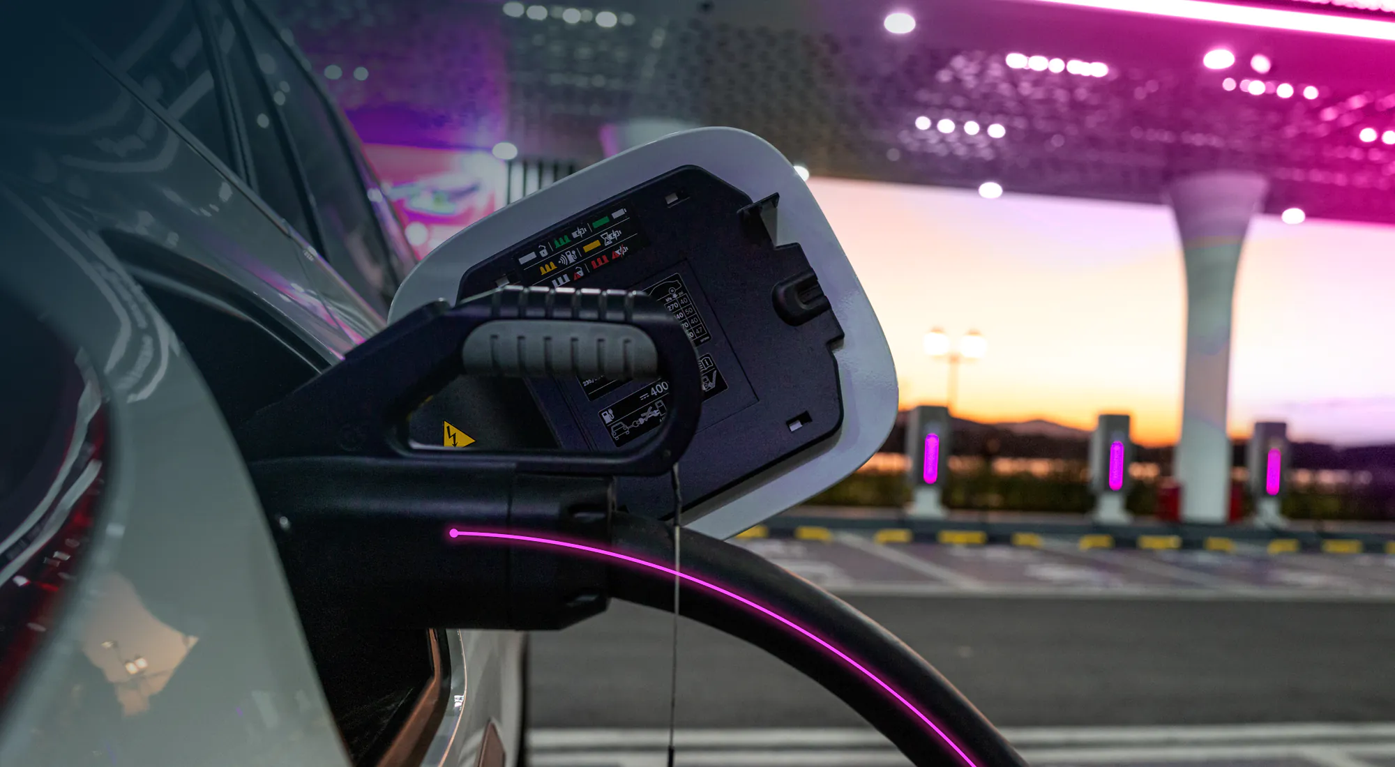 A close up on a EV charger plugged into an electric vehicle port