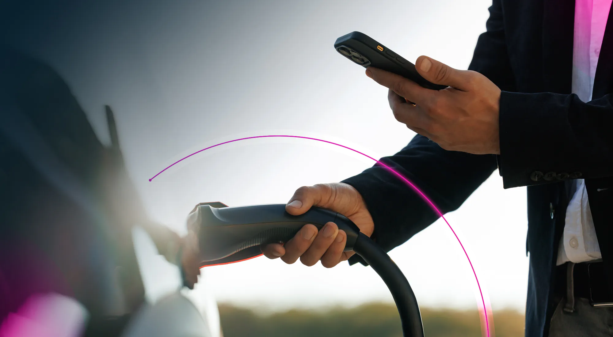 A businessman plugging in an EV charger into his car