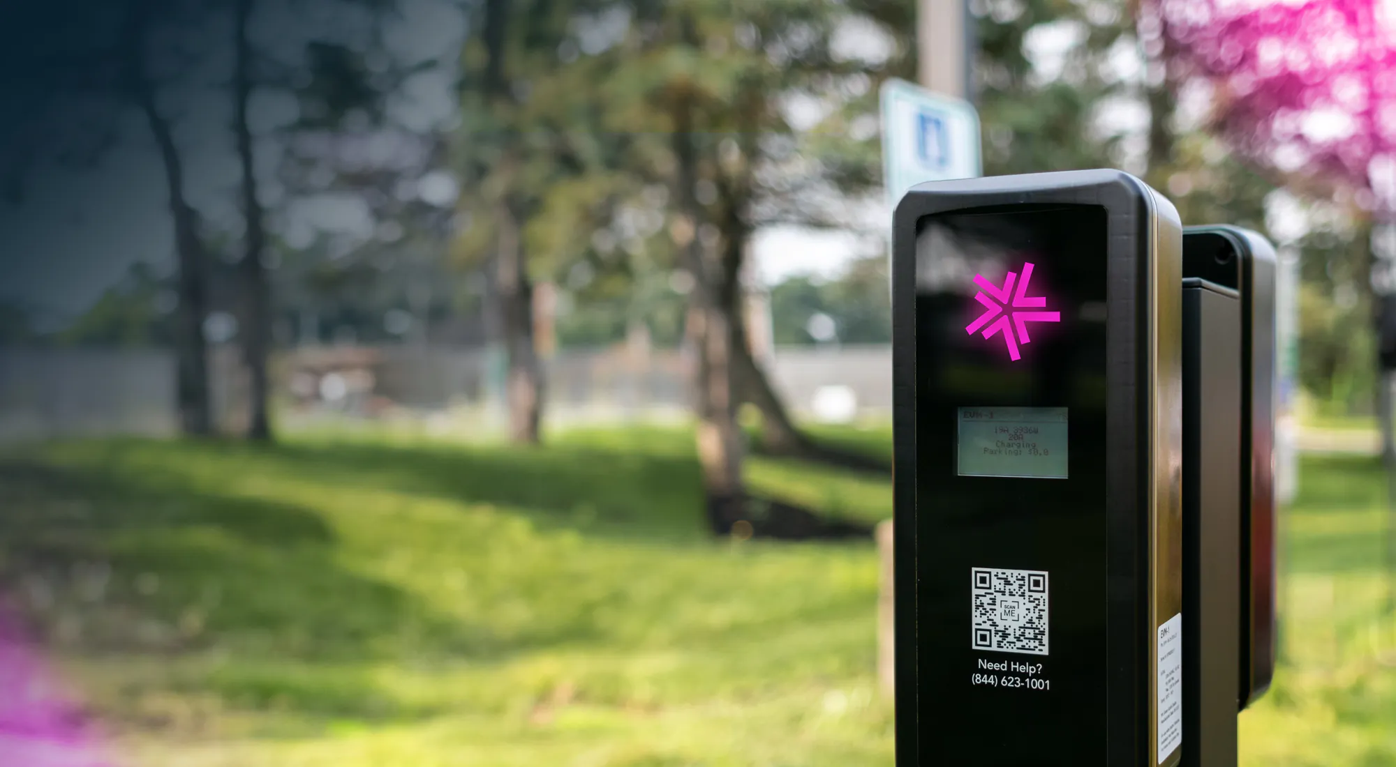 A Lynkwell EV charging station at a park with lots of trees in the background