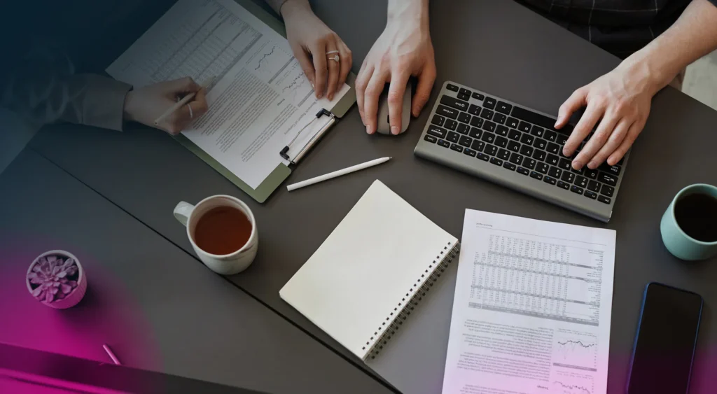 A pair of hands working at a desk going over ev charging cooperative purchasing documents