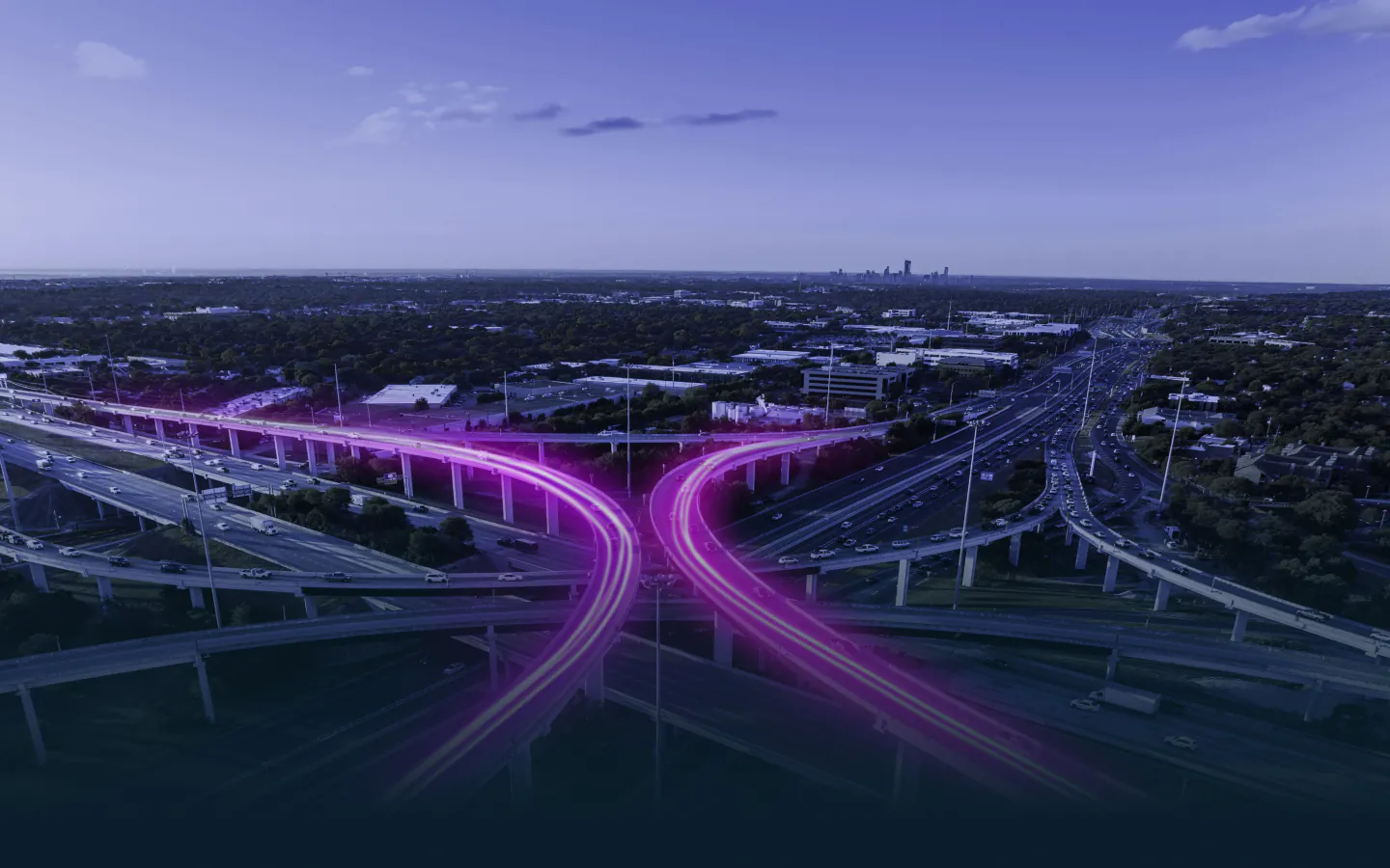 A timelapse image of cars racing down a freeway with purple light forming an "X"