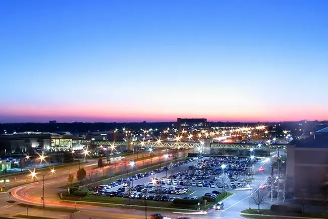 A full parking lot at night filled with EV charging stations