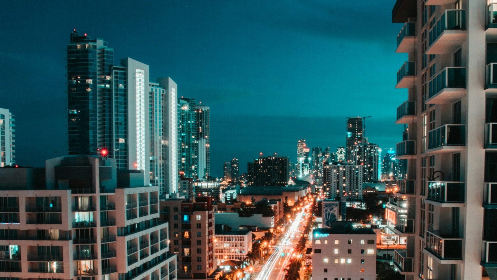 A city at night with lights from the streets below illuminating the buildings